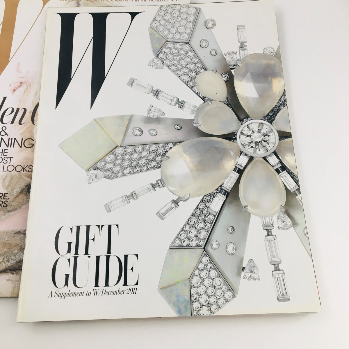 W Magazine December 2011 Gift Guide supplement cover featuring an elegant jewelry design, complementing the main issue with Dakota & Elle Fanning.