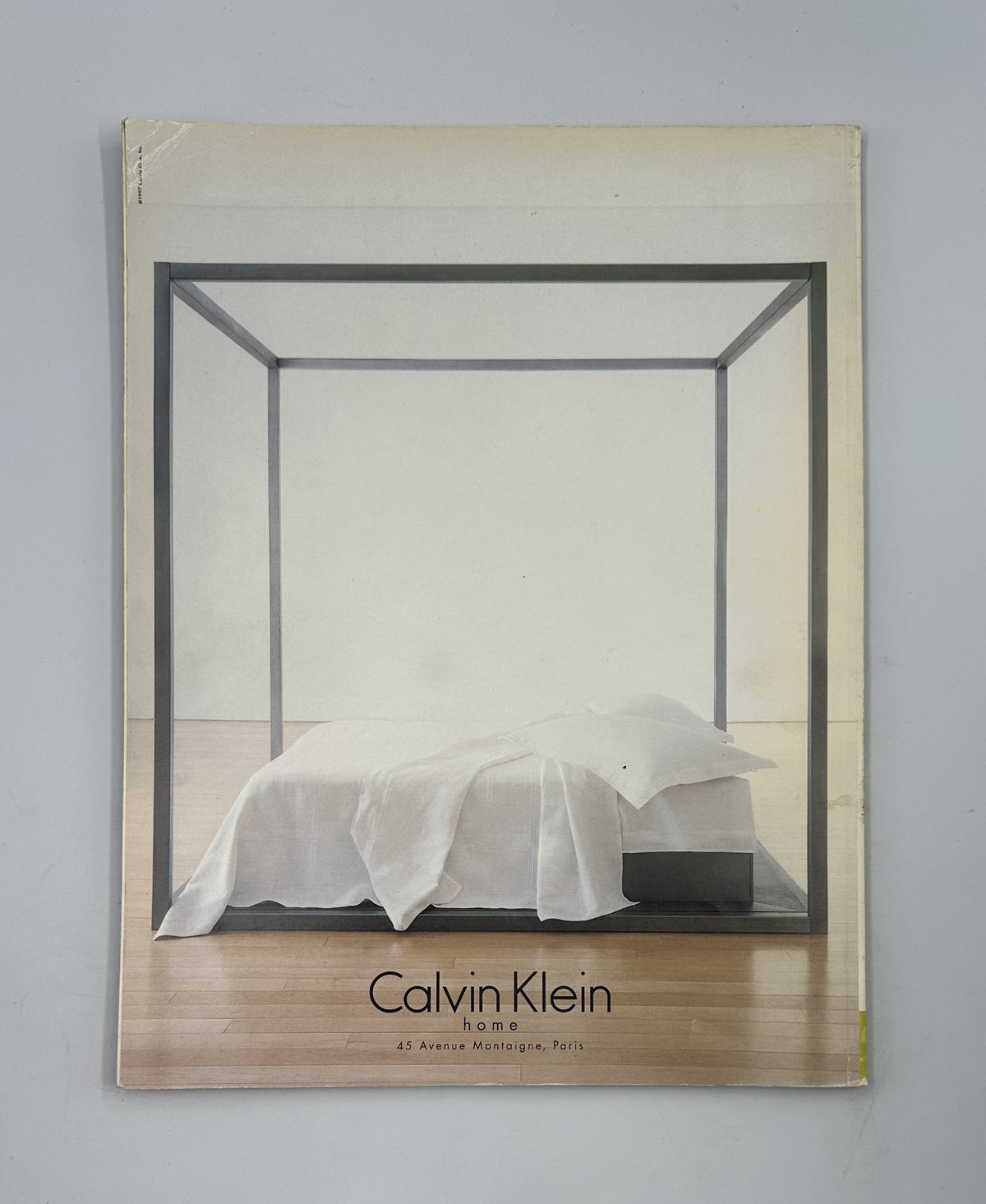 Calvin Klein Home catalog cover featuring a minimalist bedroom with a four-poster bed, designed for modern interior aesthetics.