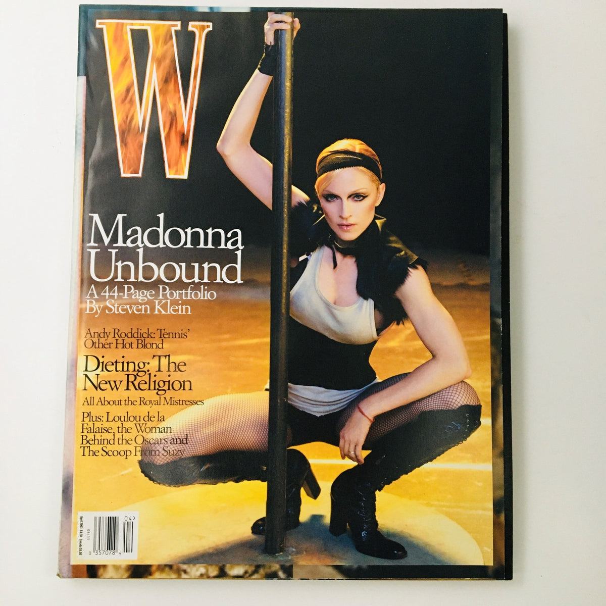 W Magazine April 2003 cover featuring singer-songwriter Madonna in the 'Unbound' feature, showcasing her artistic expression and cultural impact. The magazine highlights Madonna's iconic style, with a bold image that captures her multifaceted career, making it a collectible piece for fans of music and pop culture.