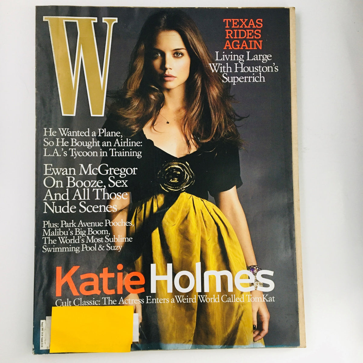 W Magazine August 2005 featuring actress Katie Holmes on the cover, showcasing her in a stylish yellow dress. The issue includes a feature on Ewan McGregor and highlights themes of pop culture from the early 2000s.