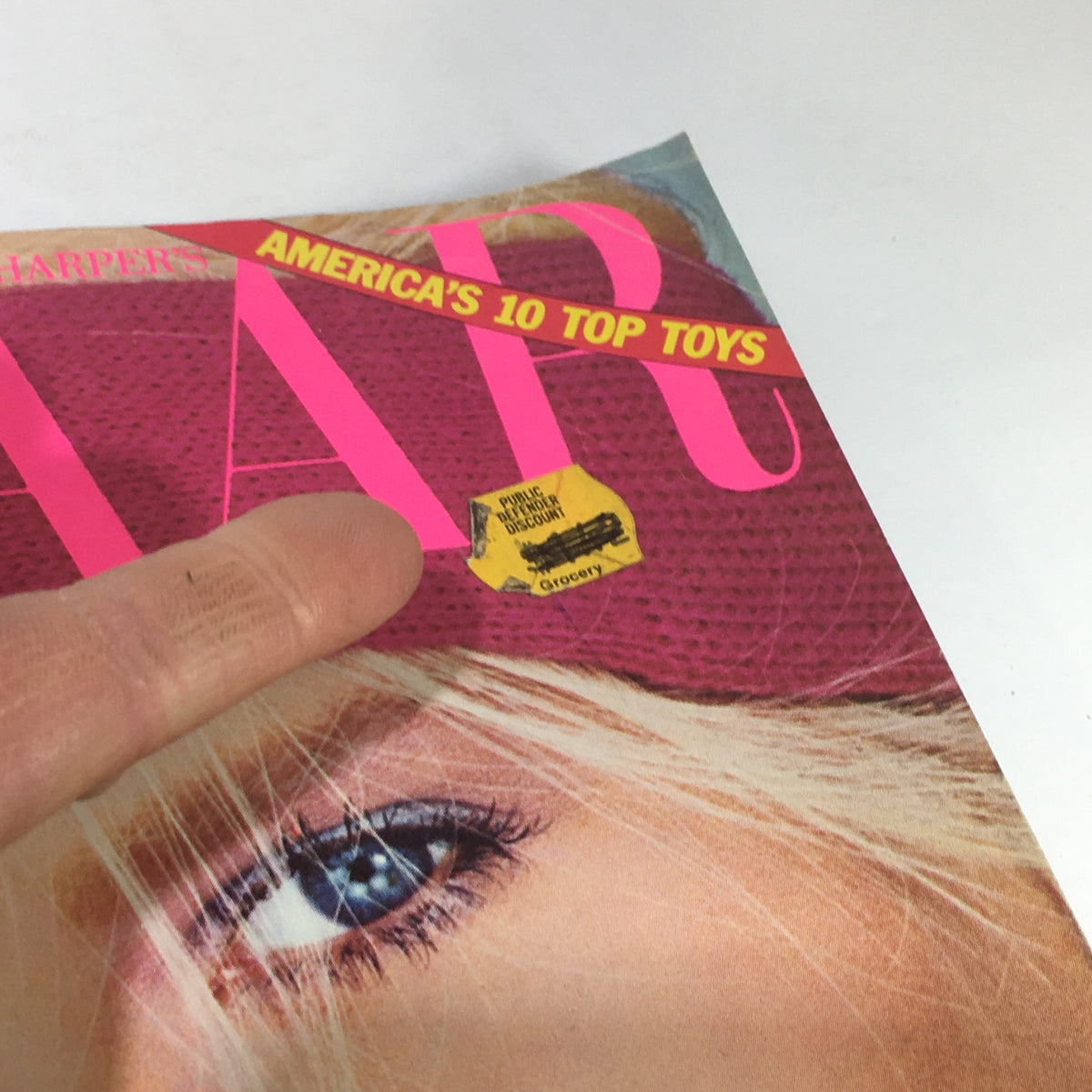 Close-up view of Bazaar Magazine December 1981 cover showing a grocery sticker label, emphasizing the magazine's unique vintage character.
