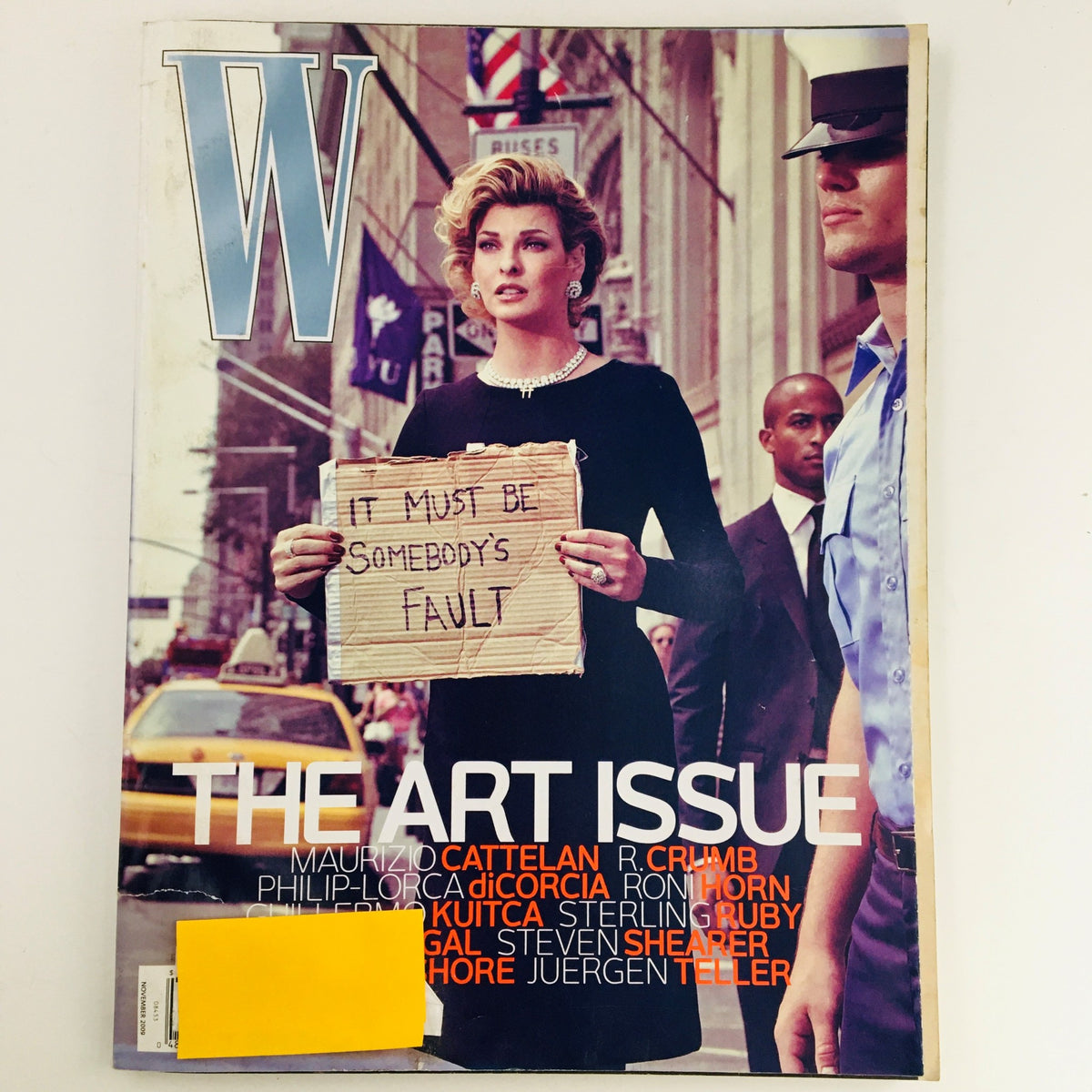 Cover of W Magazine November 2009 featuring Canadian model Linda Evangelista in The Art Issue, showcasing a dramatic scene with a woman holding a sign in a city street setting.