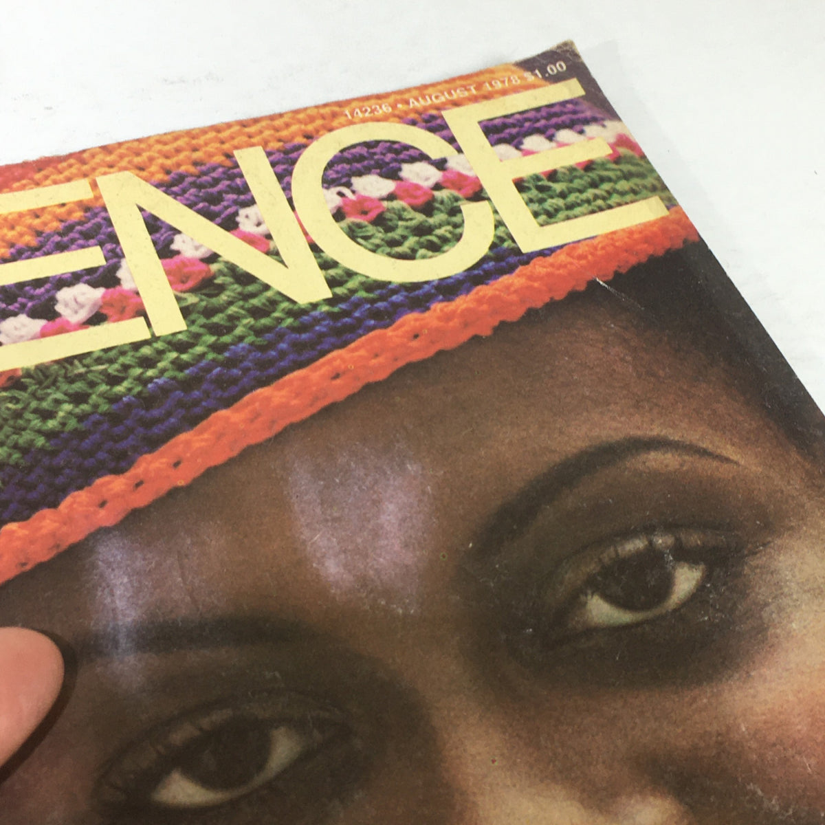 Close-up of VTG Essence Magazine: August 1978 - Bebe Moore Campbell Cover, emphasizing the intricate details of the colorful hat worn by the featured woman.