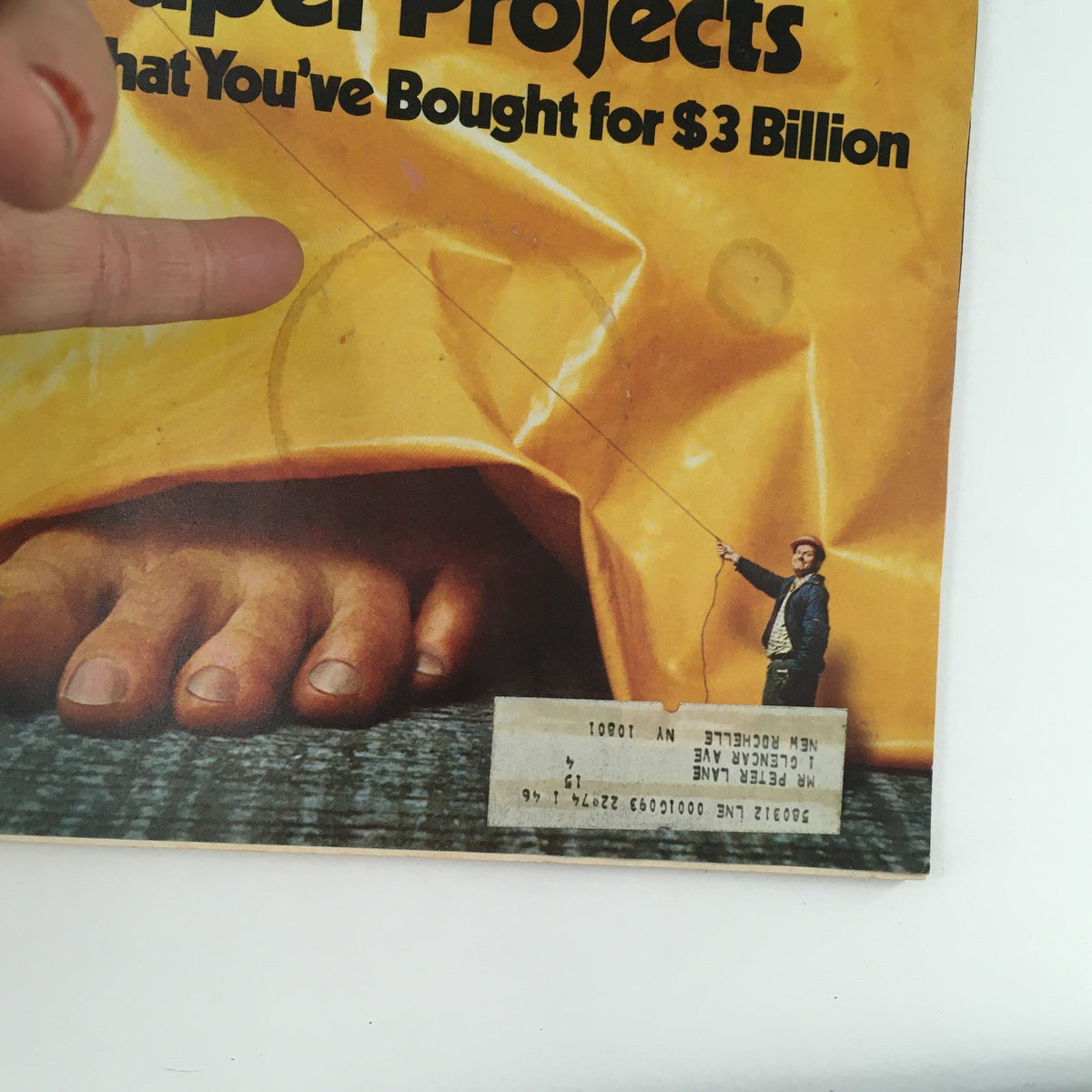 Close-up of the cover of New York Magazine, April 8, 1974, titled 'Unveiling The City's Super Projects for $3 Billion.' The image highlights a person holding a fishing line, alongside a giant foot and a visible address label.