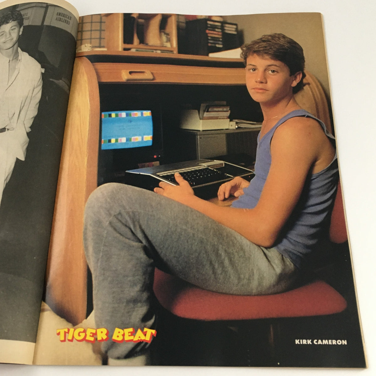 Kirk Cameron featured in Tigers Beat Magazine October 1986, posed at a computer in casual attire.