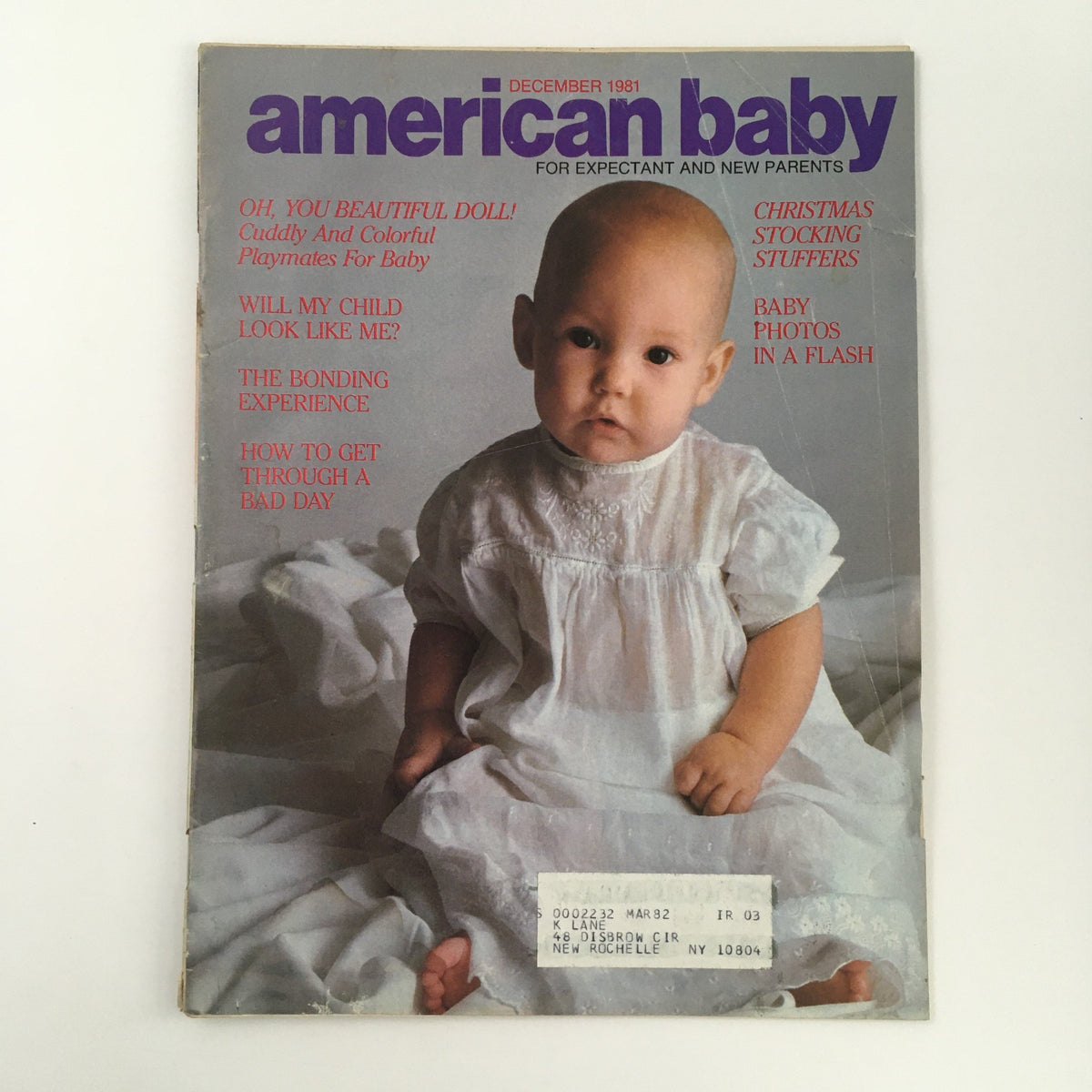 Cover of American Baby Magazine from December 1981, featuring a baby wearing a vintage white dress, with articles on parenting, holiday traditions, The Bonding Experience, and Christmas stocking ideas.