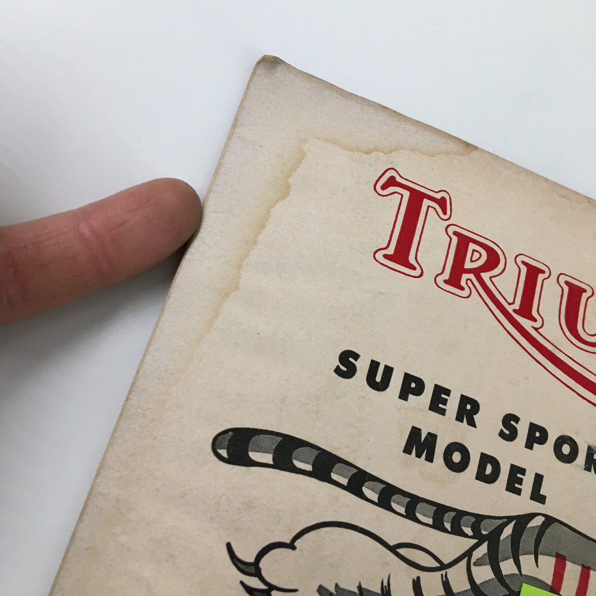 Close-up view of the top left corner of VTG Cycle Magazine June 1954, featuring the title 'TRIUMPH SUPER SPORT MODEL' with vintage paper texture.