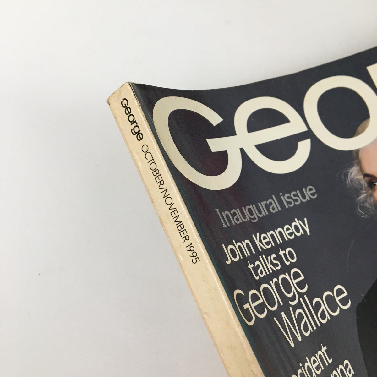 Close-up view of the spine of George Magazine October 1995 showcasing the inaugural issue title with John Kennedy and George Wallace's interview.