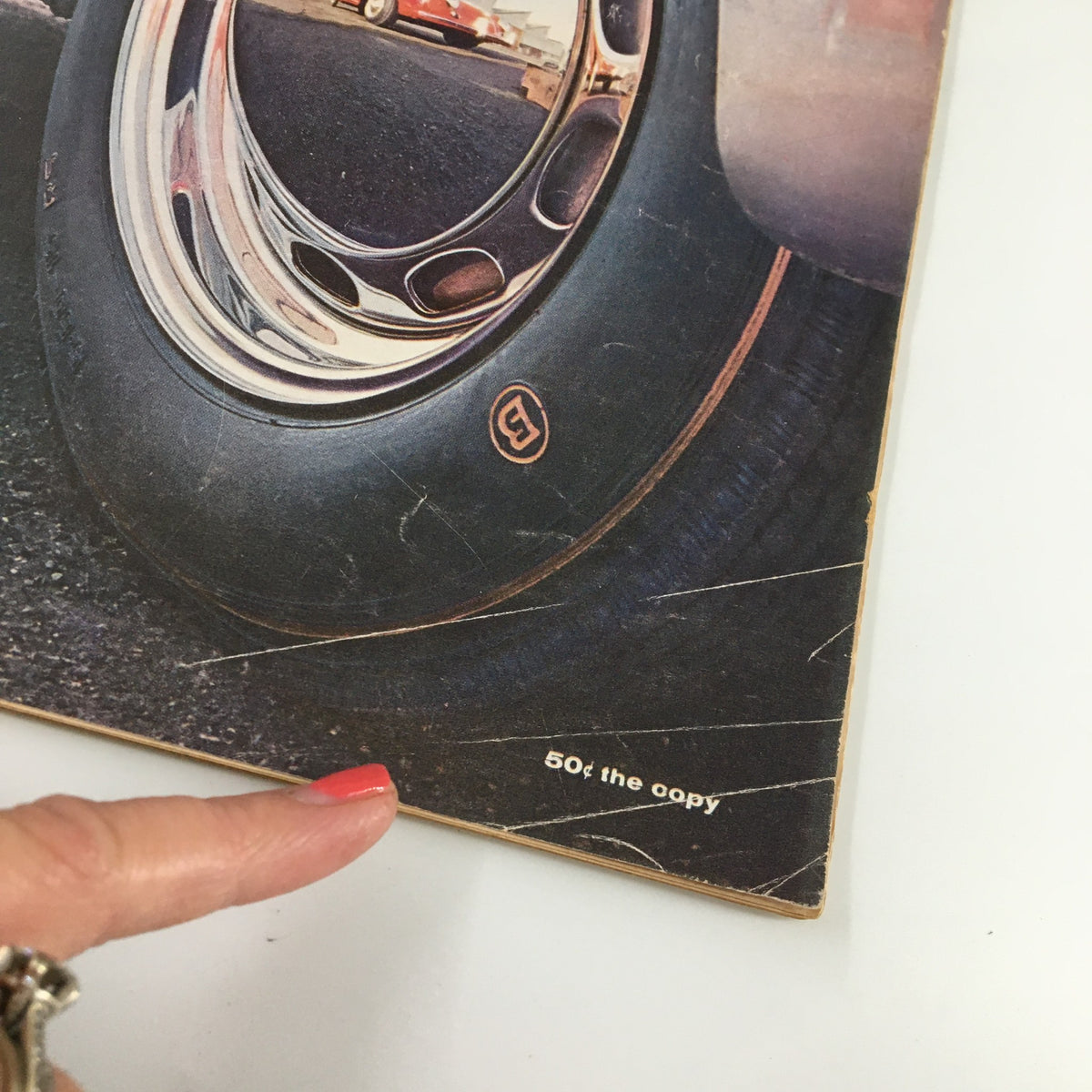 Detailed view of the bottom corner of the VTG Road & Track Magazine April 1959 cover displaying the price and design elements related to R&T staff's small car concepts.