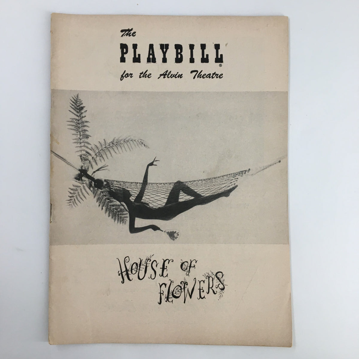 1955 Playbill for the Alvin Theatre showcasing the cover of 'House of Flowers' featuring a striking graphic of a figure in a hammock against a minimalist backdrop.
