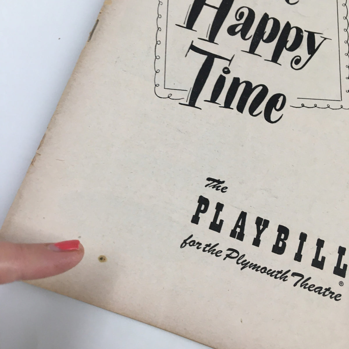 Detail of the 1951 Playbill for The Plymouth Theatre's 'The Happy Time' highlighting a minor imperfection with a finger pointing at it.