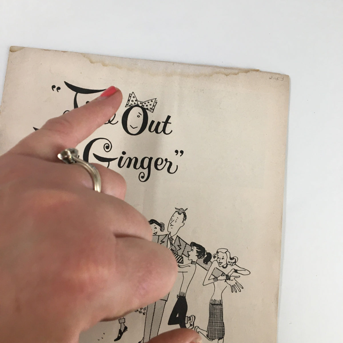 Close-up view of the vintage 1953 Playbill for 'Time Out For Ginger,' highlighting the title with an illustration and a hand pointing to the graphics.