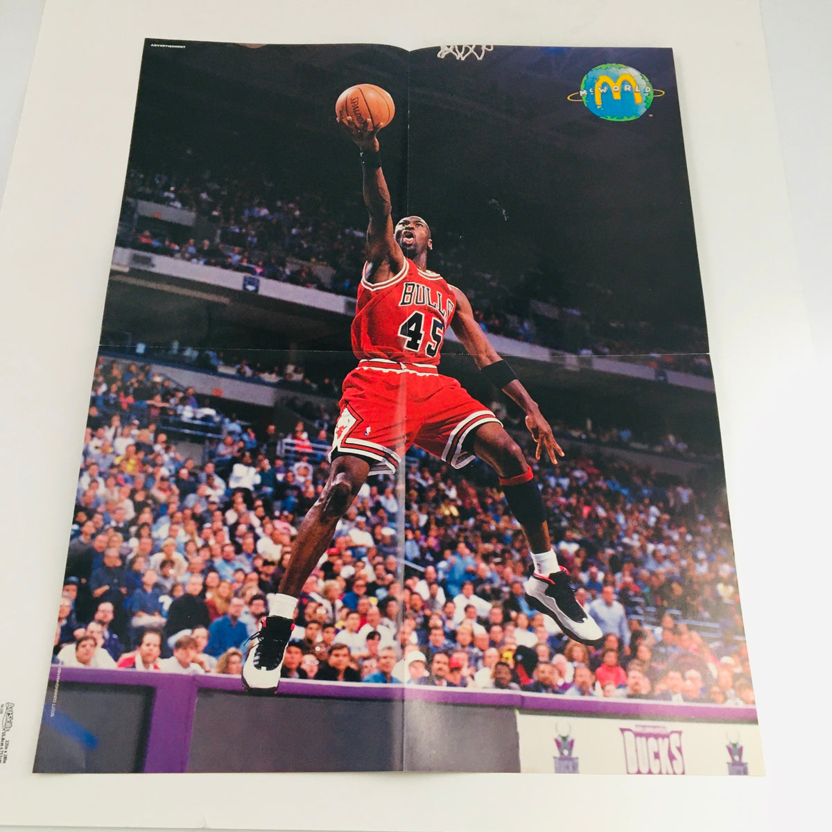 Sports Illustrated for Kids Magazine 1995 featuring Michael Jordan poster, showcasing his iconic jump in a red Bulls jersey during a game.