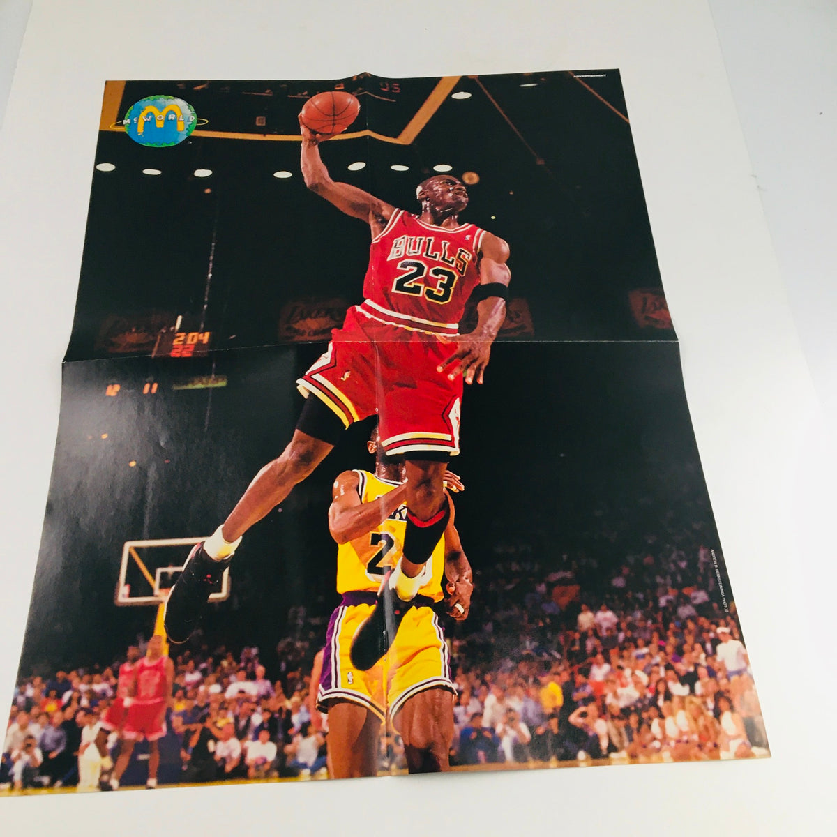 Sports Illustrated for Kids Magazine 1995 showcasing a poster of Michael Jordan in red Bulls jersey, performing a dynamic slam dunk over an opponent.