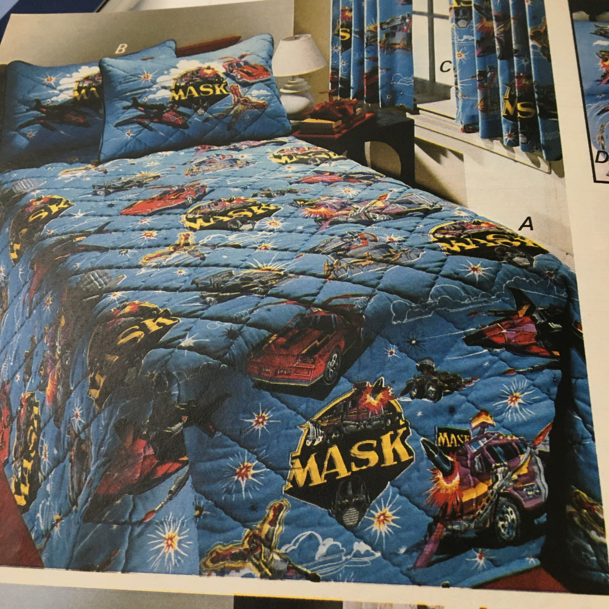 VTG 1986 Centennial Edition Fashion Apparel & Home Furnishing Catalog showing a blue quilt with MASK-themed graphics, complete with matching pillows and curtains.