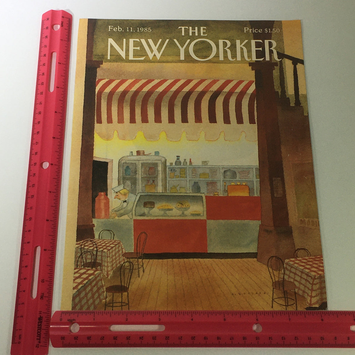 Cover of The New Yorker Magazine February 11, 1985, highlighted with a ruler for size, depicting a nostalgic café scene with a server at the dessert counter, illustrated by Abel Quezada.