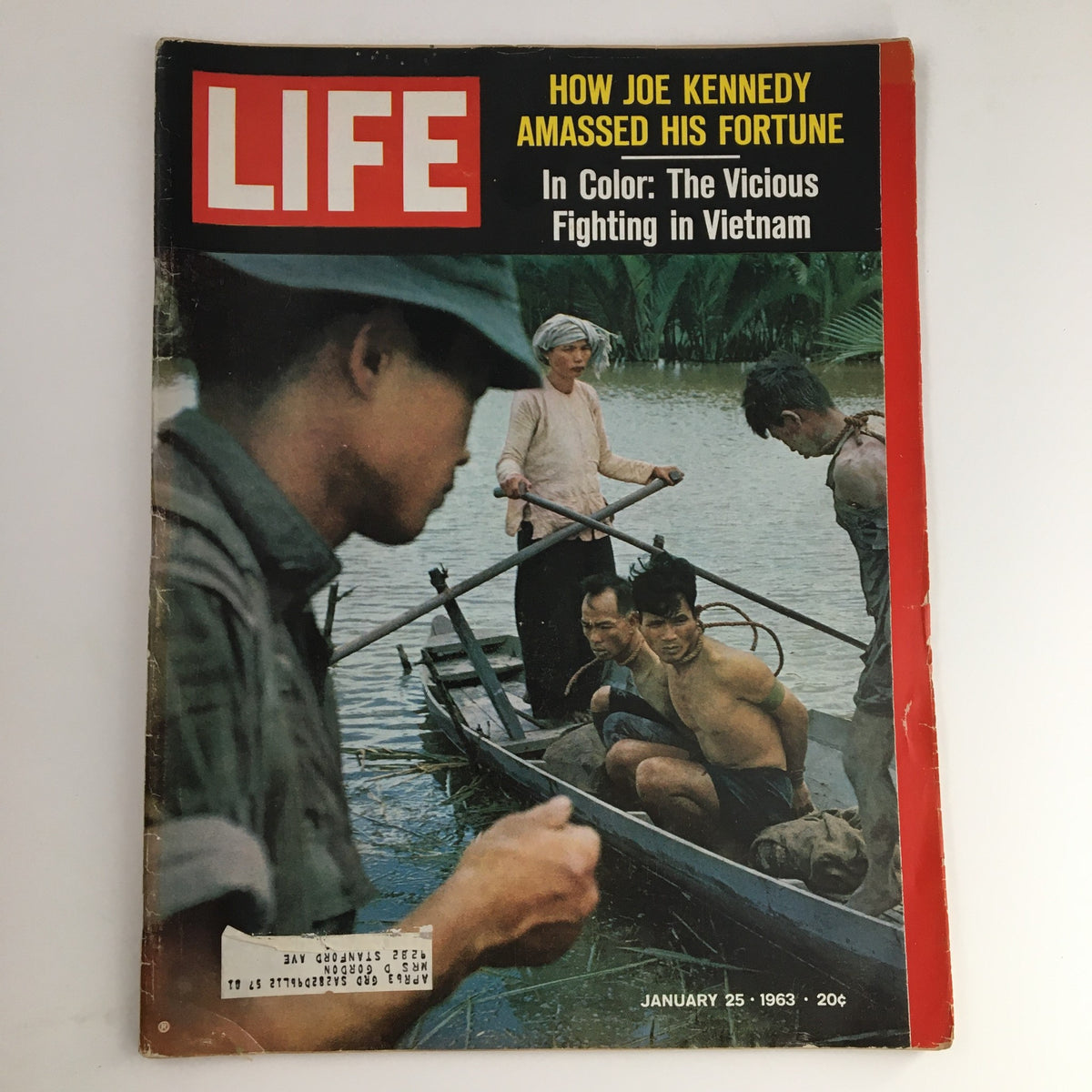 Cover of Life Magazine dated January 25, 1963, featuring the title 'How Joe Kennedy Amassed His Fortune' alongside an image depicting the Vietnam conflict, showcasing individuals in a boat with a backdrop of water and lush vegetation.