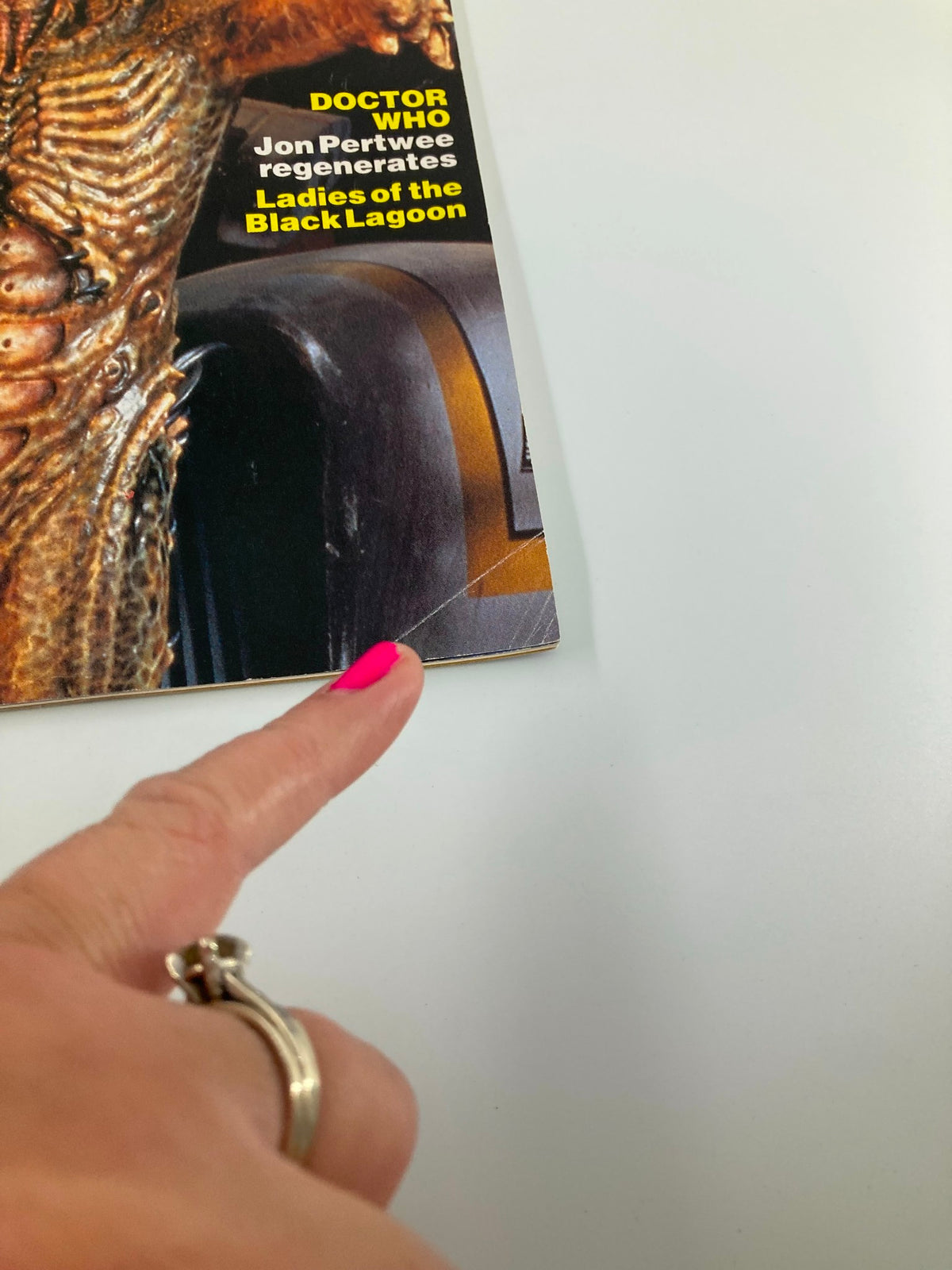 A close-up of the corner of Starlog Magazine June 1991 #167, highlighting a finger pointing to the title section which features headlines about Doctor Who, Jon Pertwee, and other pop culture themes, ideal for collectors of vintage magazines.