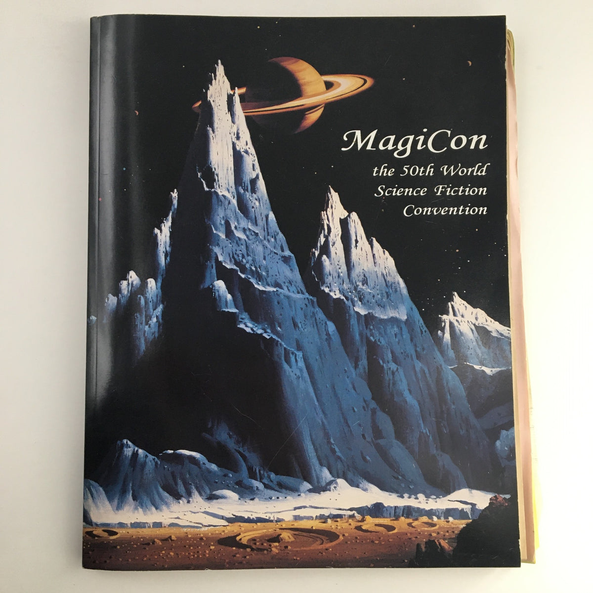 Cover of MagiCon September 1992, the 50th World Science Fiction Convention, featuring a dramatic landscape with mountains and a planet in the sky.
