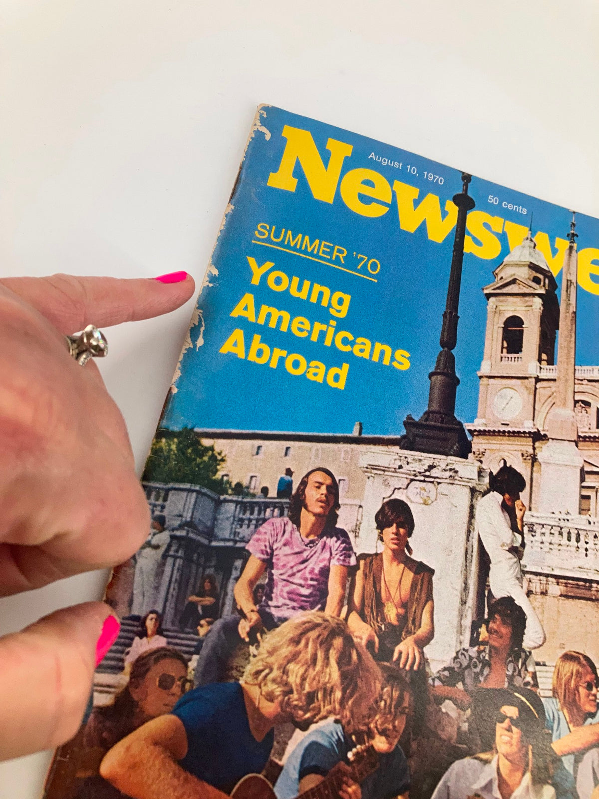 Close-up of the VTG Newsweek Magazine August 10 1970 cover highlighting the title 'Young Americans Abroad' with hand pointing to the vintage magazine, emphasizing its authentic summer 1970 design.
