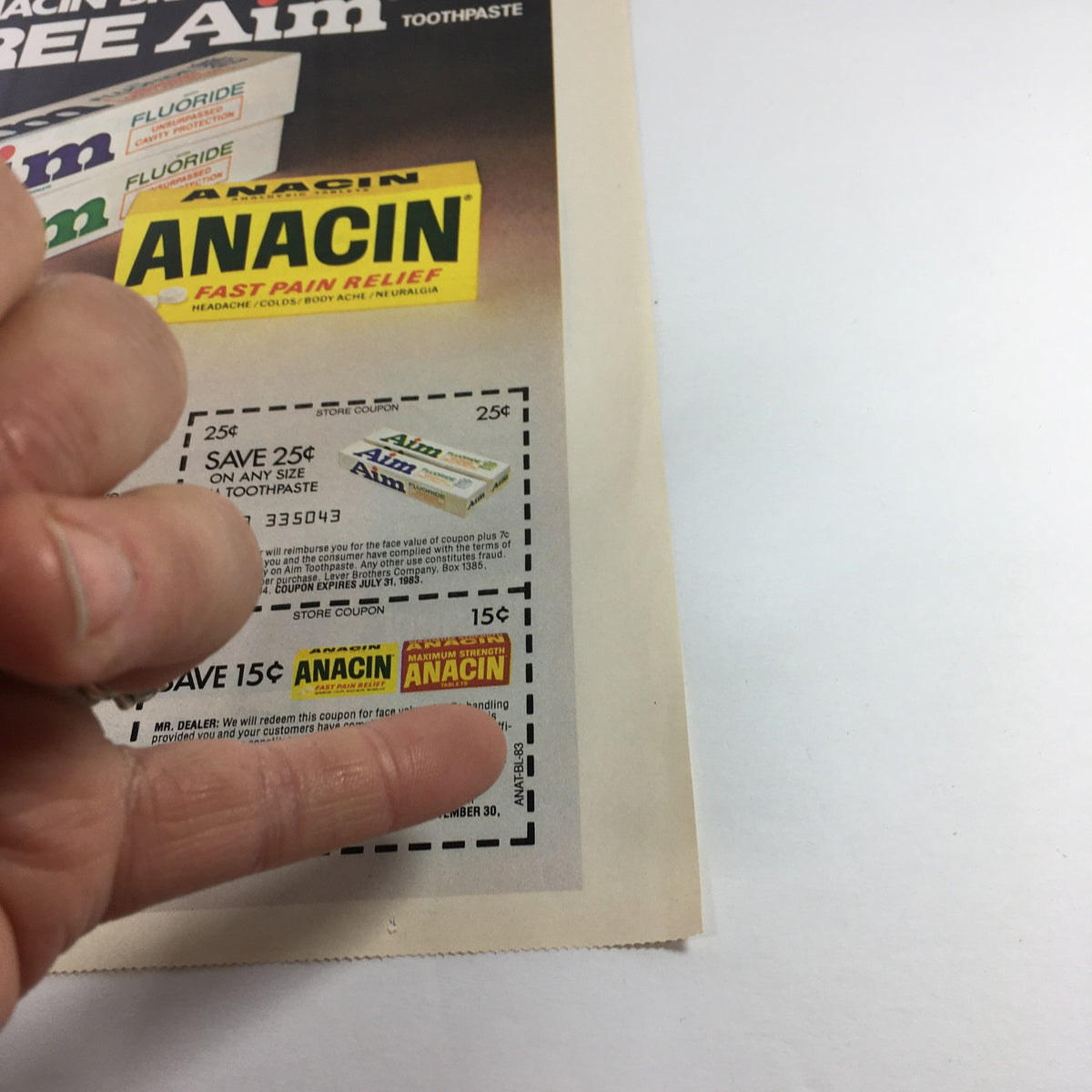 Close-up of the VTG Retro 1983 Anacin Analgesic Tablet and Aim Toothpaste Print Ad highlighting store coupons for discounts on Anacin and Aim products.