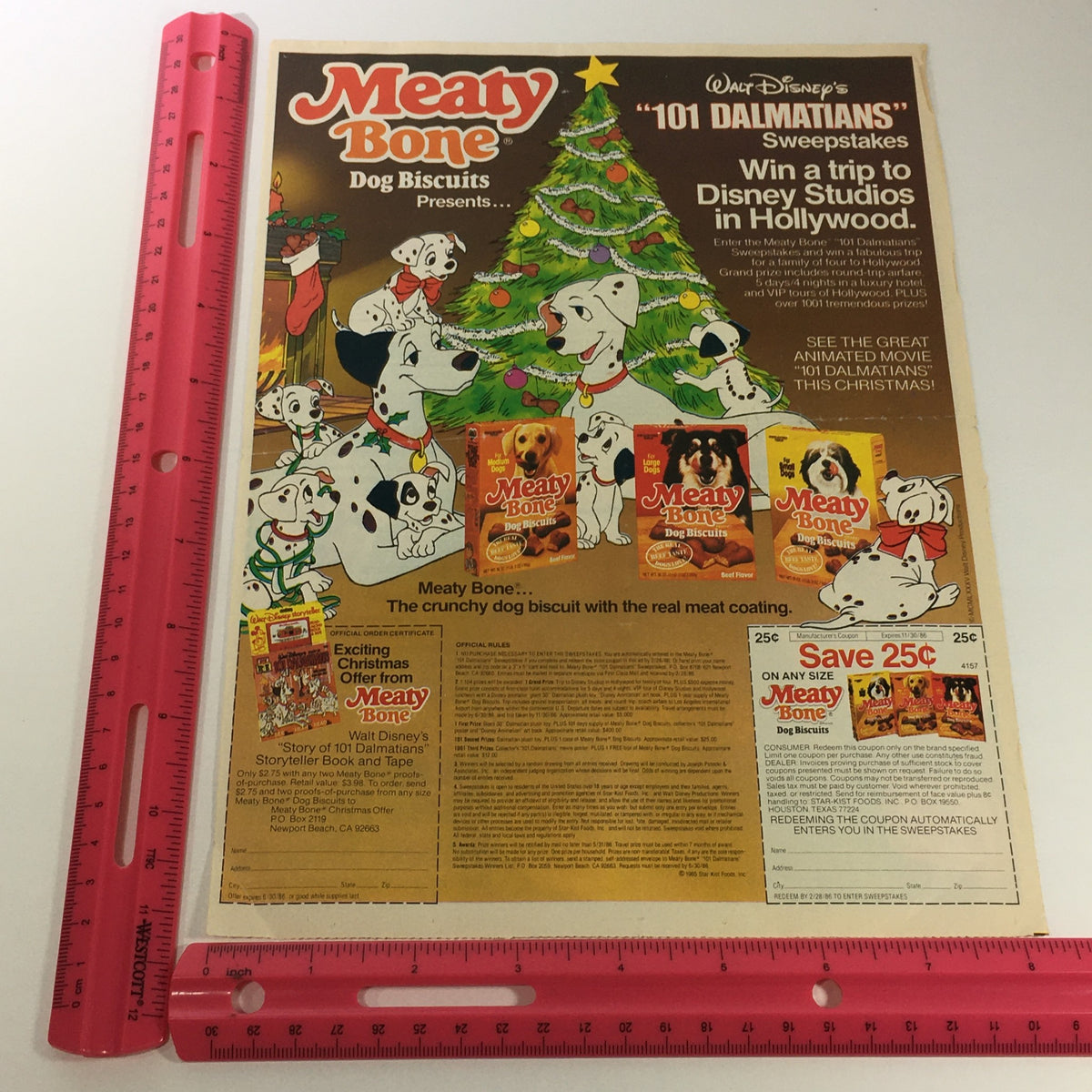 Vintage advertisement for VTG Retro 1986 Meaty Bone Dog Biscuits featuring 101 Dalmatians theme. The ad showcases playful Dalmatians around a Christmas tree, promoting a sweepstakes offering a trip to Disney Studios. The colorful layout includes product images and a coupon for savings, capturing the nostalgia of 1980s pet food marketing.