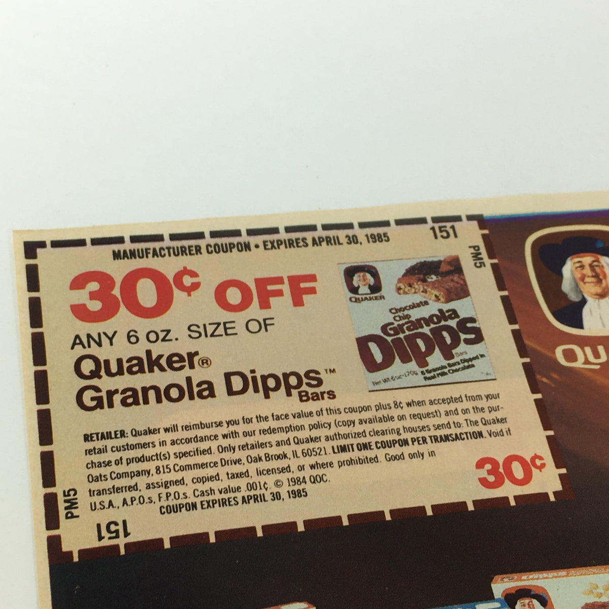 Close-up of a vintage coupon for 30 cents off any Quaker Granola Dipps bars, valid until April 30, 1985, showcasing promotional details and a nostalgic design.
