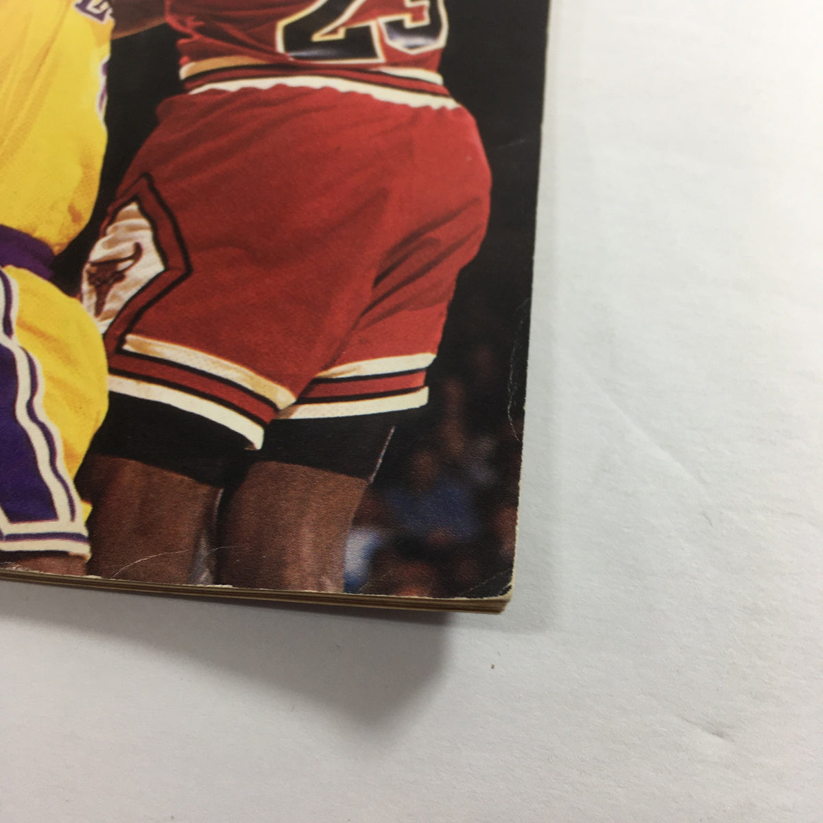 Close-up of the cover of VTG Inside Sports Magazine October 1990, highlighting the details of Michael Jordan's red basketball uniform as he competes with Orlando Woolridge during an intense NBA matchup.