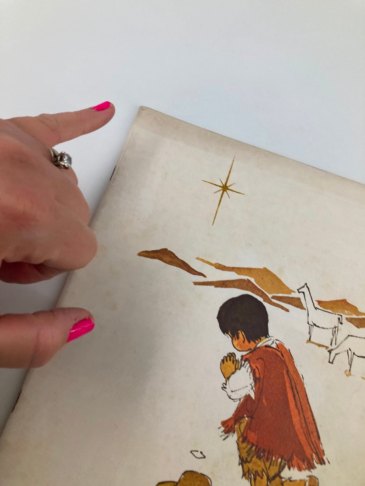 Detail view of the VTG Christian Living Magazine December 1966 cover, focusing on the boy in prayer and a star, with a finger indicating the star.