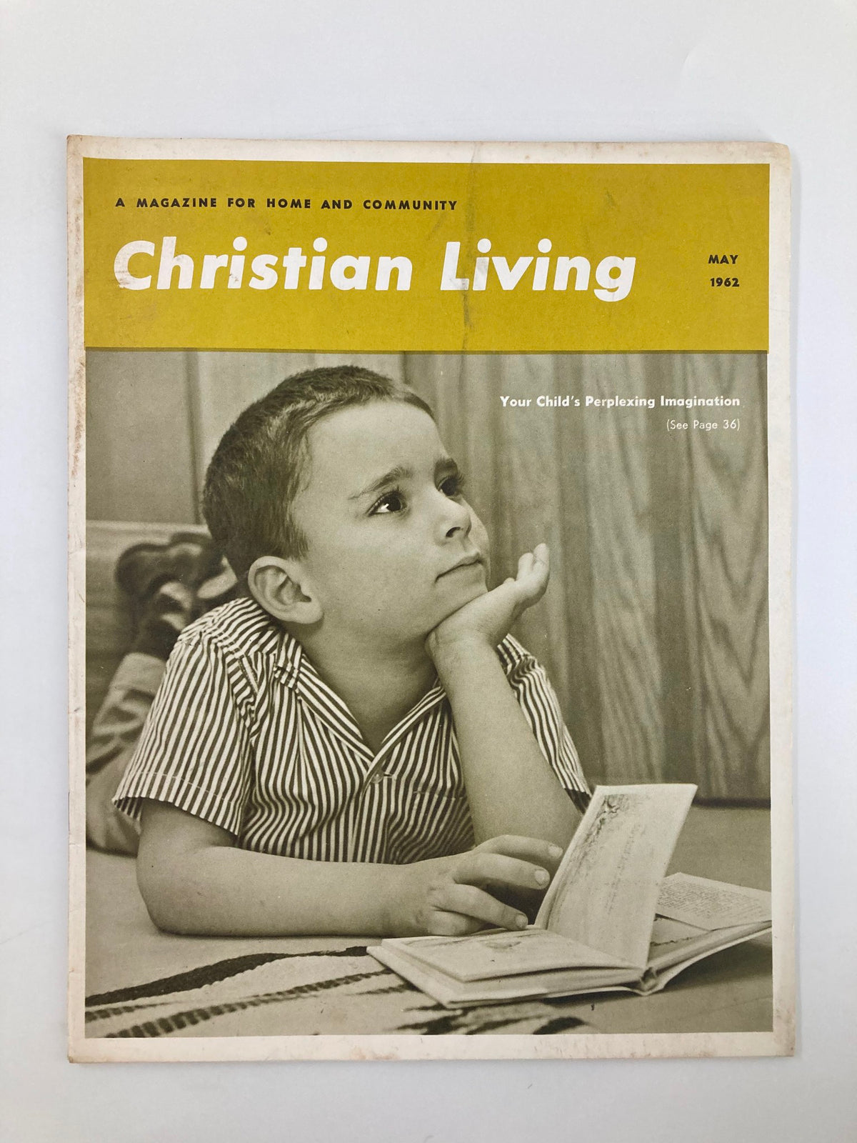 Cover of VTG Christian Living Magazine, May 1962, featuring a boy in striped pajamas thoughtfully looking at an open book, illustrating the theme 'Your Child's Perplexing Imagination'.