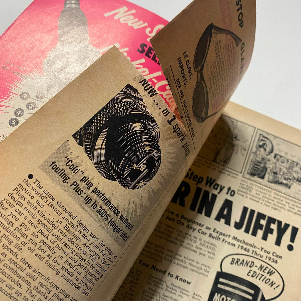 Interior page of VTG Motor Trend Magazine November 1956 displaying an advertisement for spark plugs, highlighting performance features.