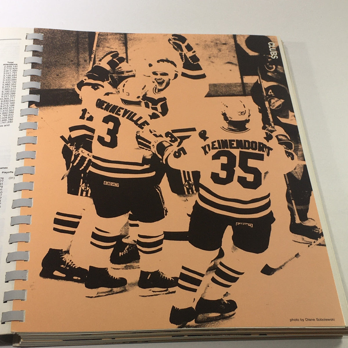 VTG NHL Official Guide & Record Book 1985-1986 showcasing an artistic black and white image of hockey players celebrating a goal, including players in vintage jerseys.