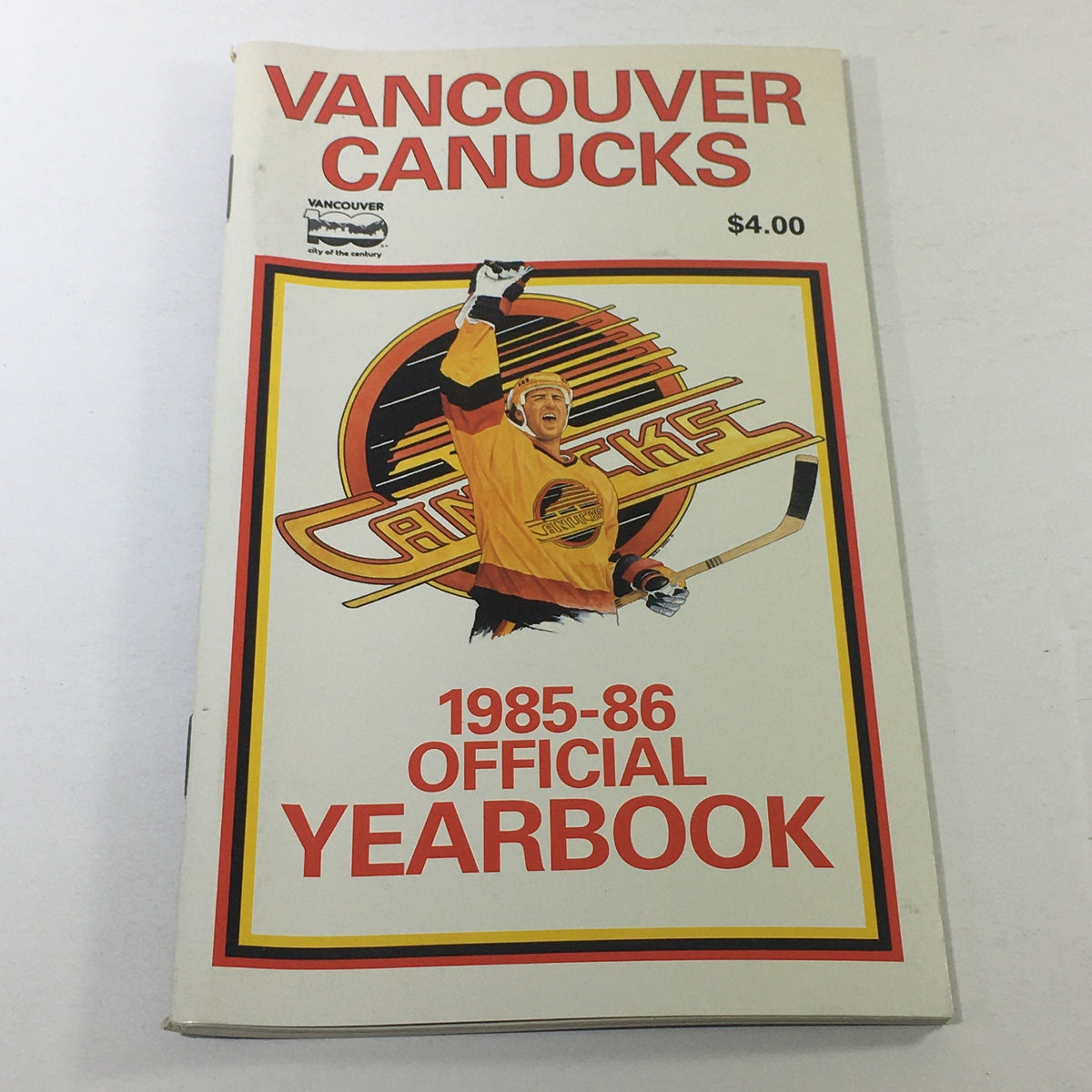 VTG NHL Official Yearbook 1985-1986 - Vancouver Canucks, featuring a colorful cover illustration of a Canucks player in action, with the Canucks Skate Logo prominently displayed.
