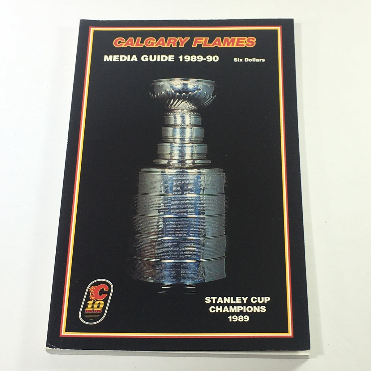 VTG NHL Official Media Guide 1989-1990 featuring the Calgary Flames and the Stanley Cup Champions trophy. The cover displays the trophy prominently with a black background and text labeling it as the official media guide.