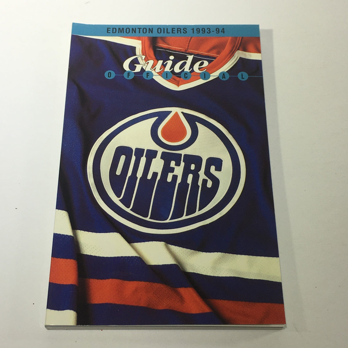 Official guide for the Edmonton Oilers from 1993-94, featuring the team's logo on a jersey background, emphasizing team pride and branding.