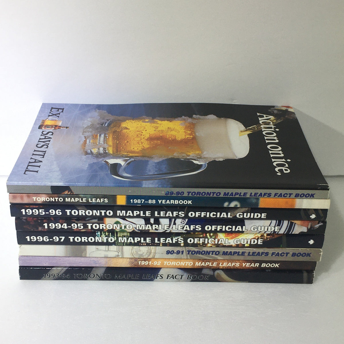 Lot of 8 VTG NHL Official Toronto Maple Leafs Official Guide Yearbook 1987-1997 stacked view of Toronto Maple Leafs magazines including Yearbooks and Official Guides highlighting nostalgic hockey memorabilia from 1987 to 1997.