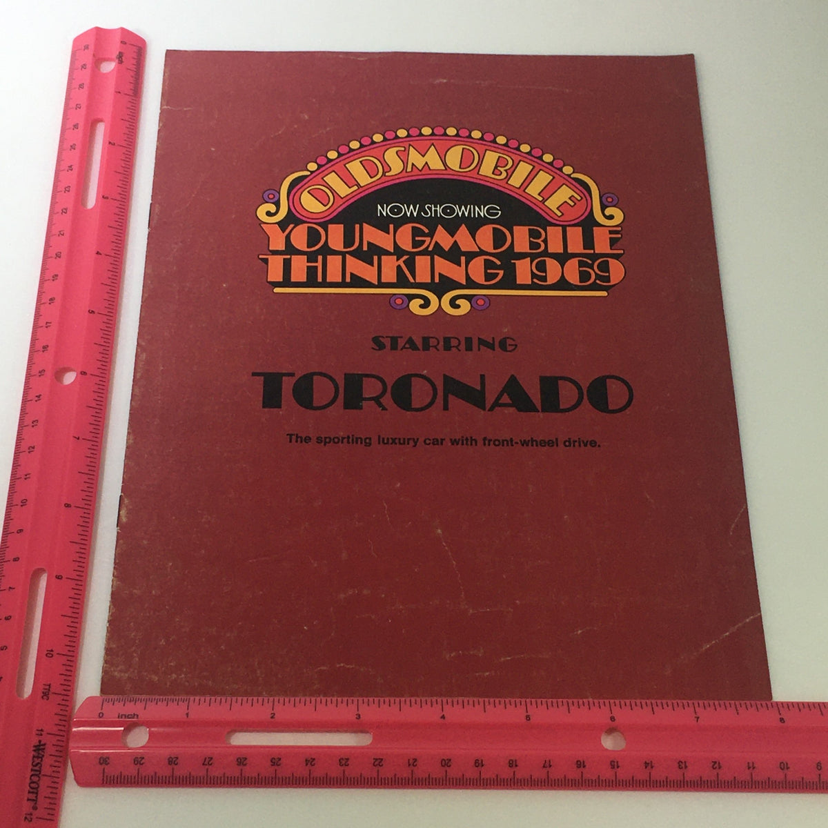 Front cover of the VTG 1969 Oldsmobile Toronado Sporting Luxury Car Auto Brochure Catalog highlighting the Toronado model with decorative graphics.