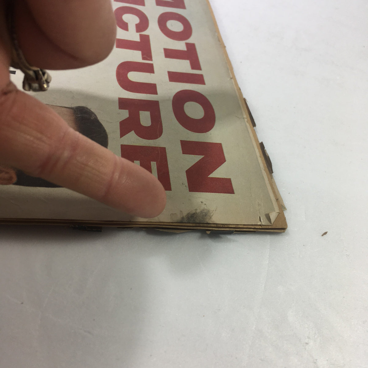 Close-up of a vintage VTG Motion Picture Magazine from June 1959, highlighting wear on the cover. Features a finger pointing at a marked area, relevant to the magazine title showcasing Shirley Boone and Pat Boone.
