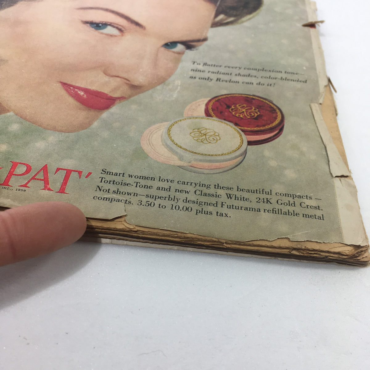 Angle view of the back cover of the June 1959 VTG Motion Picture Magazine, pointing to a torn edge and text about compacts. Relates to the article featuring Shirley Boone and Pat Boone.