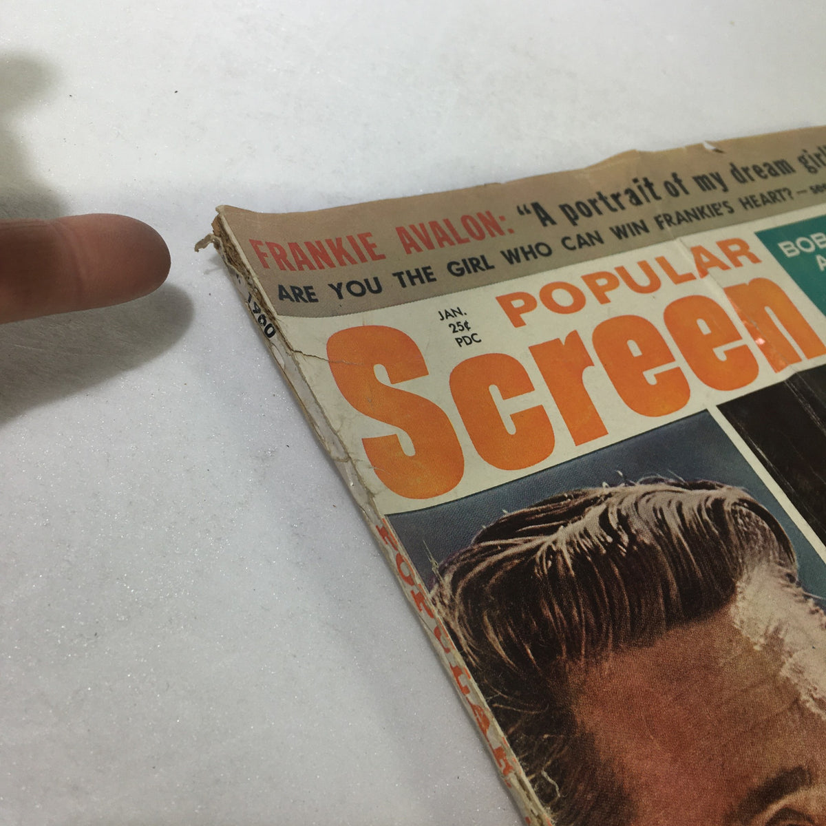 Close-up of the January 1960 Popular Screen Magazine featuring edge wear and damage, showcasing historical value for collectors.
