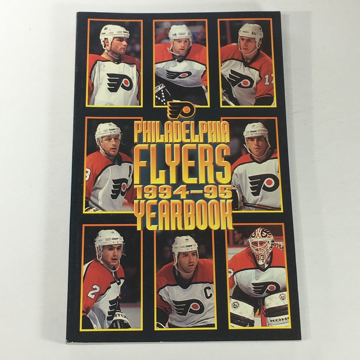 Cover of the VTG NHL Official Yearbook 1994-1995 featuring the Philadelphia Flyers and showcasing various players, including Dmitry Yushkevich.