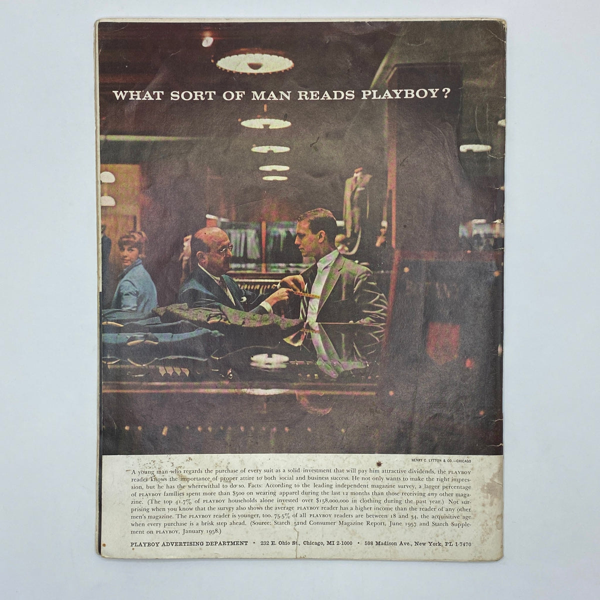 Back cover of VTG Playboy Magazine May 1958 displaying an advertisement with the question 'WHAT SORT OF MAN READS PLAYBOY?' featuring a stylish clothing store scene.