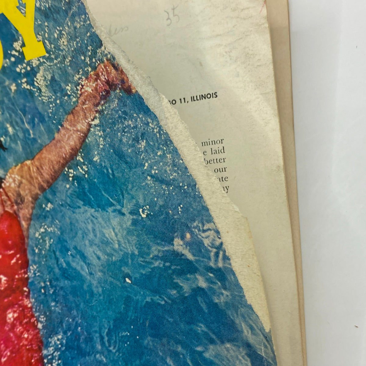 Close-up of the edge of the Playboy Magazine June 1956 cover showing wear and texture, revealing the historical charm of this vintage publication.