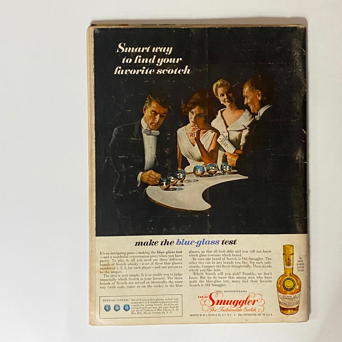 Back cover of VTG Playboy Magazine December 1960 featuring a vintage advertisement for scotch, showcasing stylish models in classic attire.