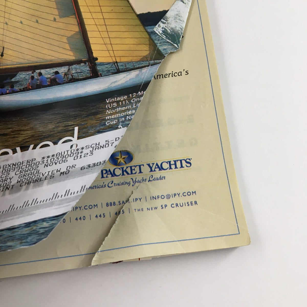 Close-up of the back cover of Cruising World Magazine November 2006, highlighting damage and wear, including a torn section and visible address label.
