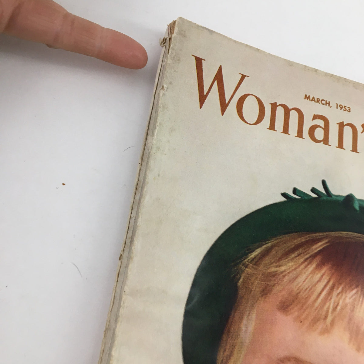 Close-up of the March 1953 cover of Woman's Day Magazine, highlighting the title and the charming illustration of a girl in a green hat.