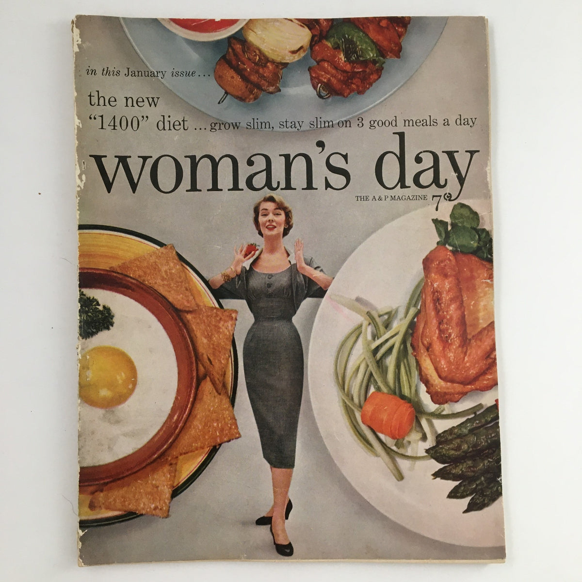 Cover of Woman's Day Magazine January 1954 featuring the theme 'The Music in Your Life,' showcasing a woman in a vintage dress surrounded by plates of food.