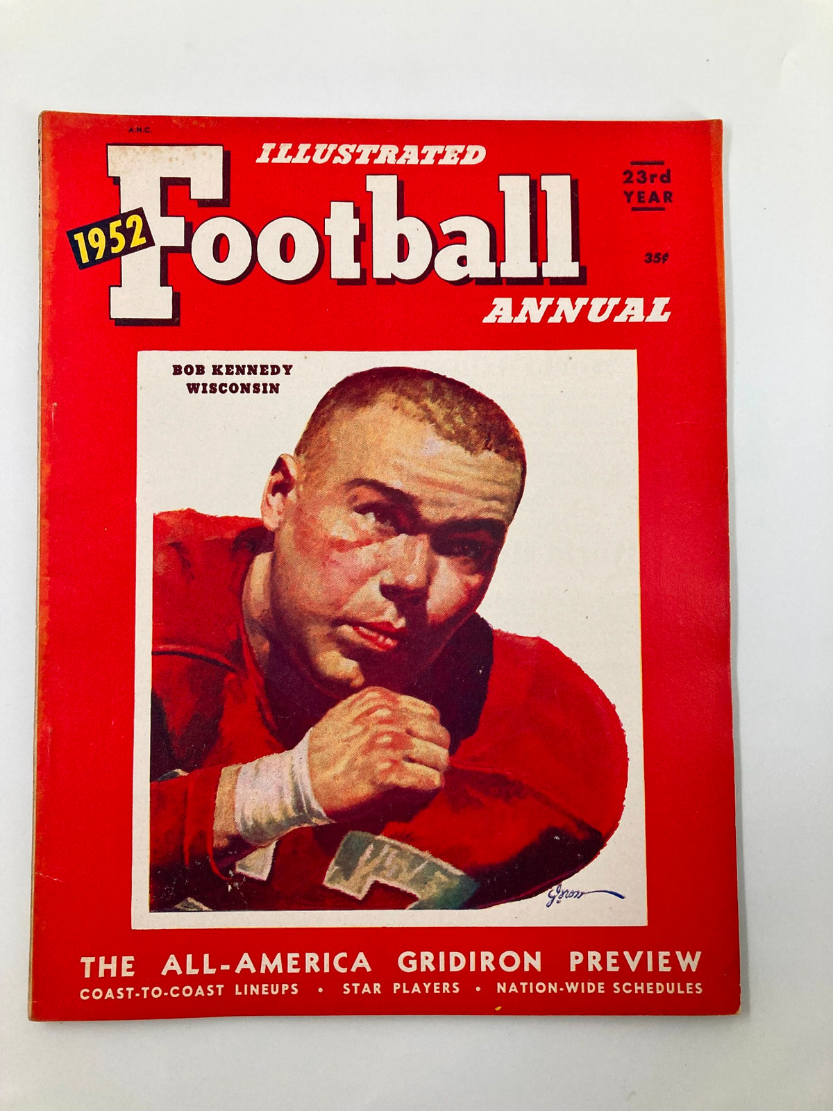 Cover of the VTG Illustrated Football Annual 1952 featuring Bob Kennedy of Wisconsin, a vintage magazine showcasing college football history, with a striking illustration of a football player and bold red design.