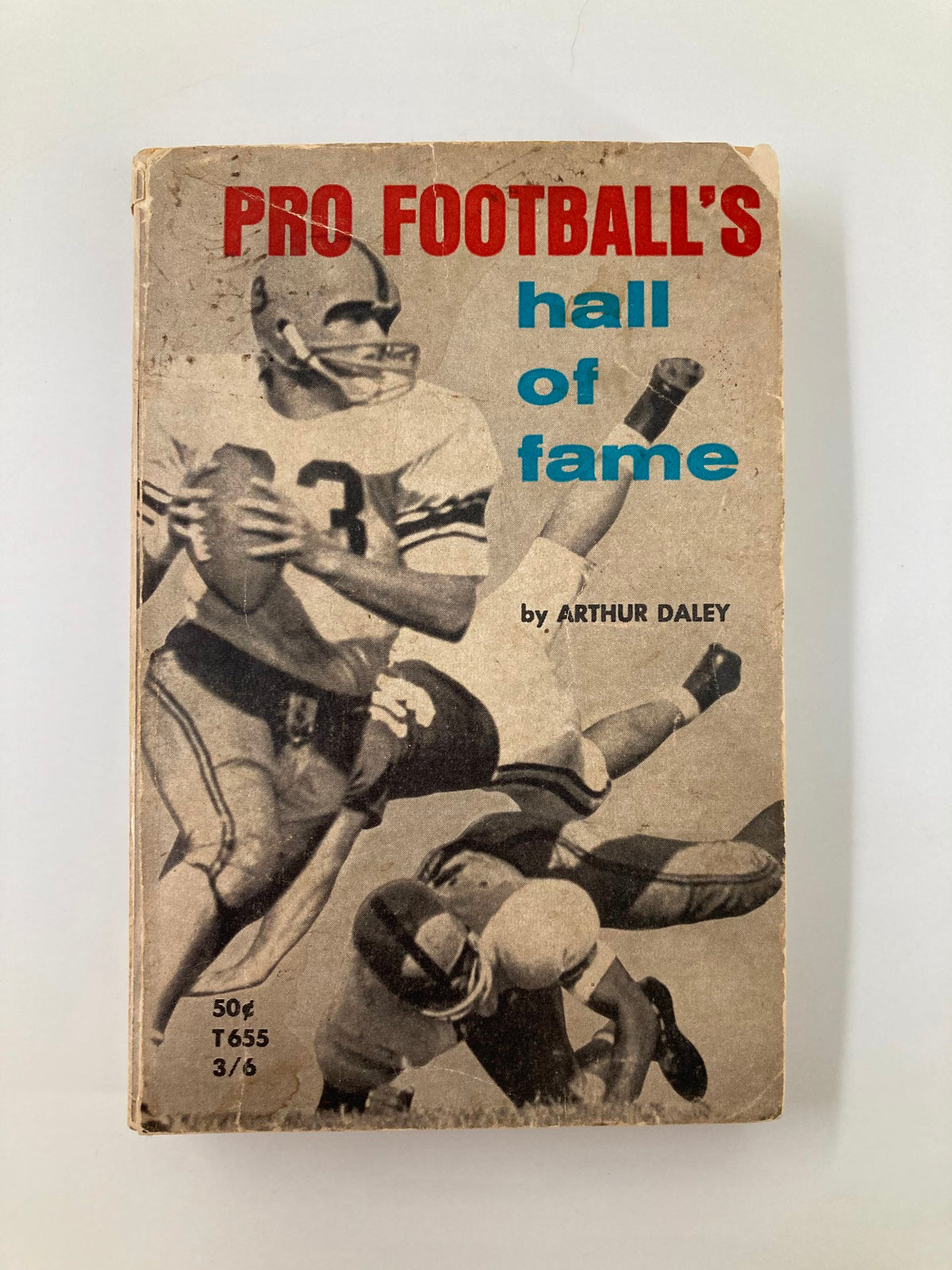 Vintage 1963 Pro Football's Hall of Fame book cover by Arthur Daley featuring a dynamic football illustration of players in action.