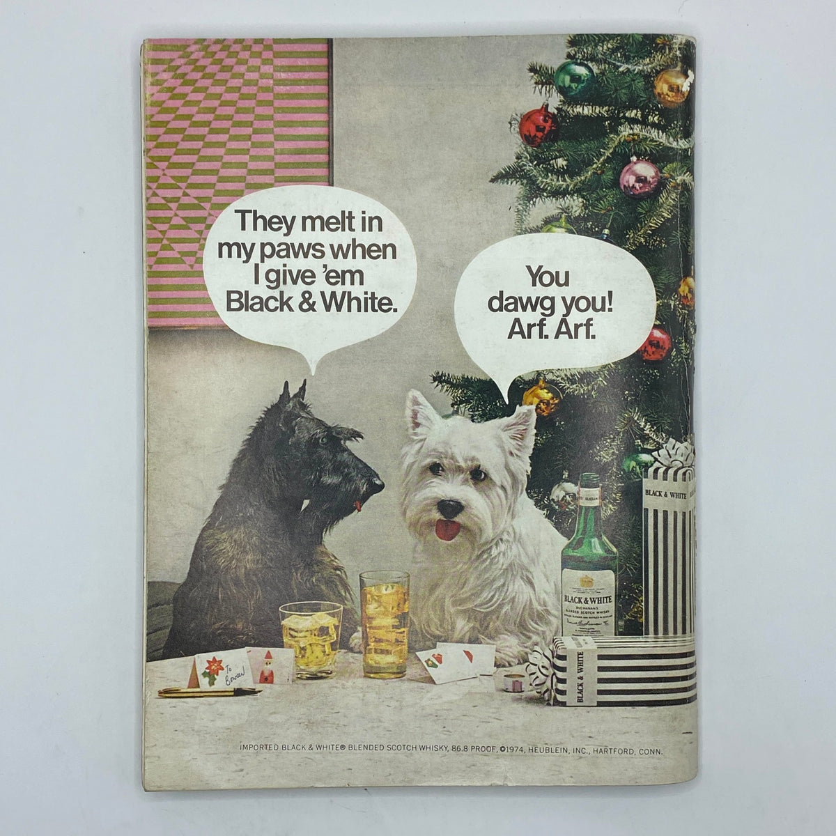 Cover of VTG Playboy Magazine December 1974 featuring a humorous advertisement with two dogs and text balloons. The scene includes a decorated Christmas tree, drinks, and playful dialogue, showcasing a vintage marketing style.